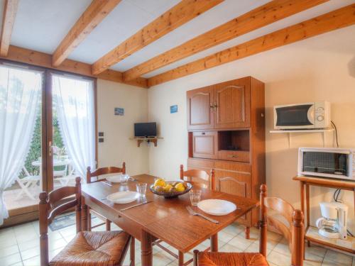a kitchen and dining room with a wooden table and chairs at Holiday Home Jardins de l'Océan-1 by Interhome in Saint-Georges-de-Didonne