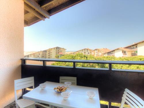 une table blanche et des chaises sur un balcon dans l'établissement Apartment Douc-7 by Interhome, à Seignosse