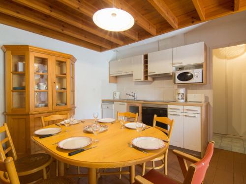 een keuken met een houten tafel met stoelen en een eetkamer bij Holiday Home Juncades by Interhome in Seignosse