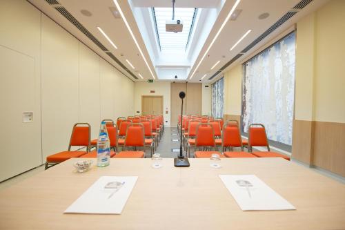 a conference room with a long table and orange chairs at Best Western Hotel Luxor in Turin