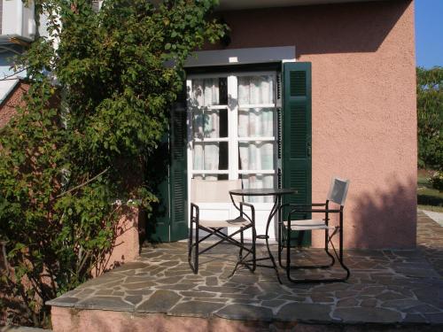 two chairs and a table in front of a window at Heliatoras Studios in Loutrópolis Thermís