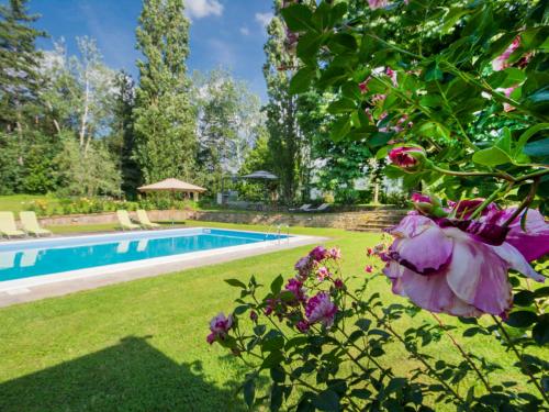 a garden with a swimming pool and flowers at Apartment I Tigli by Interhome in Rufina