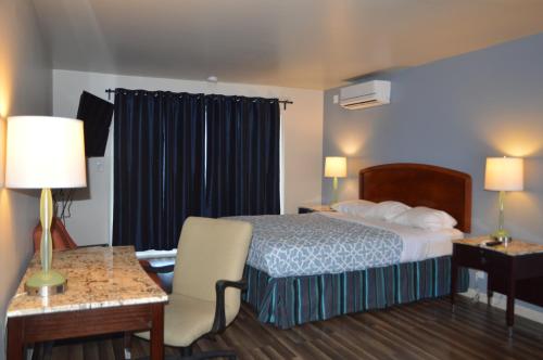 a hotel room with a bed and a desk at Glass Slipper Inn - Stanford Palo Alto in Palo Alto