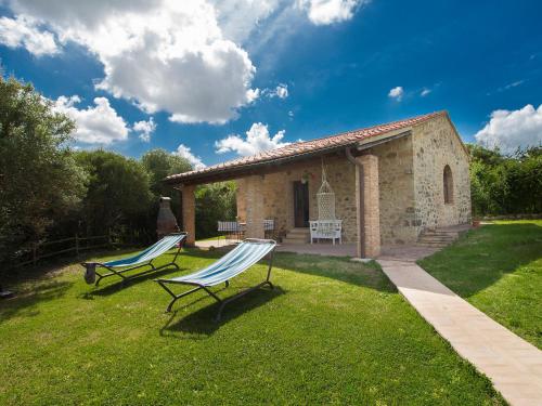 two chairs sitting in the grass in front of a building at Holiday Home Sweet Maremma by Interhome in SantʼAntonio