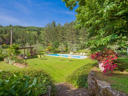 a garden with a swimming pool and flowers at Apartment I Tigli by Interhome in Rufina
