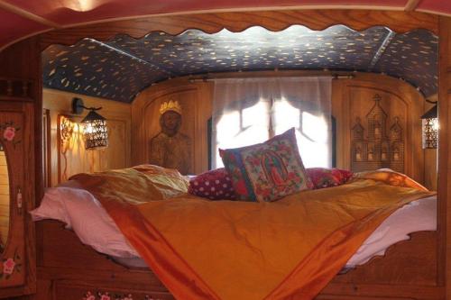 un letto a baldacchino in una stanza con finestra di La roulotte "Les Saintes" a Saintes-Maries-de-la-Mer