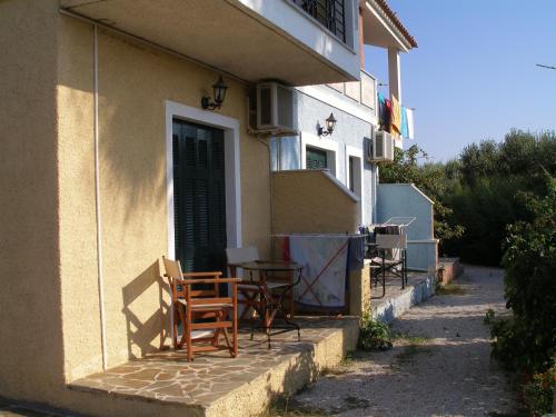 a patio with chairs and a table on the side of a building at Heliatoras Studios in Loutrópolis Thermís