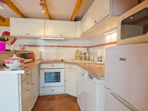 une cuisine avec des armoires blanches et un réfrigérateur blanc dans l'établissement Holiday Home Le Clos du Rigaud-1 by Interhome, à Cavalaire-sur-Mer