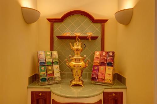 a shelf with a vase on a table with books at Hotel Garni Schneider in Lutago