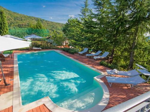 a swimming pool with lounge chairs and a mountain at Villa Villa Campo del Mulino by Interhome in Piteccio