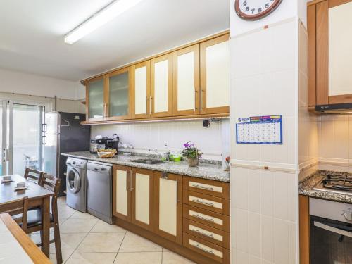 a kitchen with wooden cabinets and a dishwasher at Apartment T2 Olhão by Interhome in Olhão
