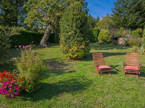 two chairs sitting in the grass in a garden at Villa Villa Campo del Mulino by Interhome in Piteccio