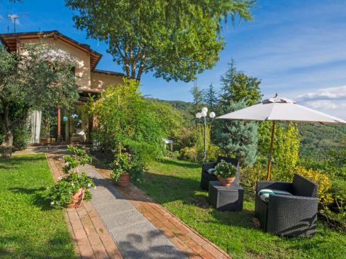 a patio with two chairs and an umbrella at Villa Villa Campo del Mulino by Interhome in Piteccio