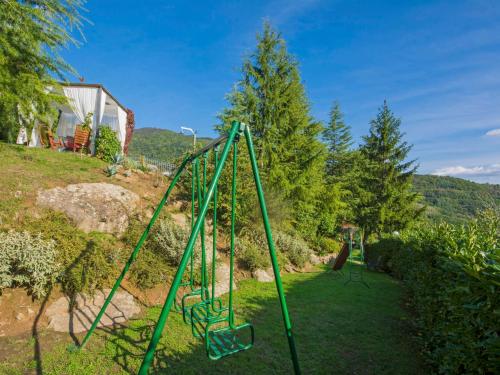 a green swing set in a yard at Villa Villa Campo del Mulino by Interhome in Piteccio