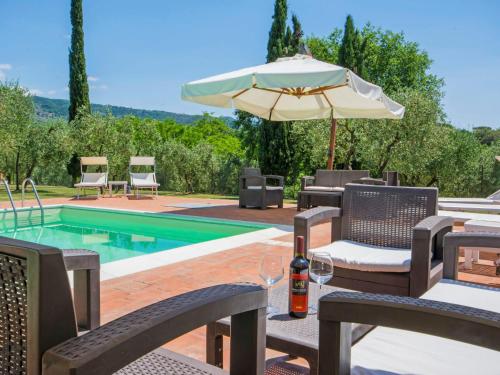 a patio with chairs and an umbrella and a pool at Villa Beboli by Interhome in Lamporecchio