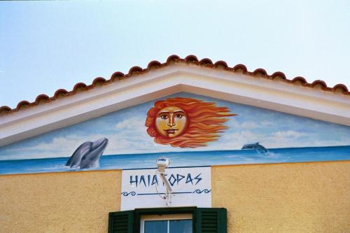 a painting on the side of a building with dolphins at Heliatoras Studios in Loutrópolis Thermís