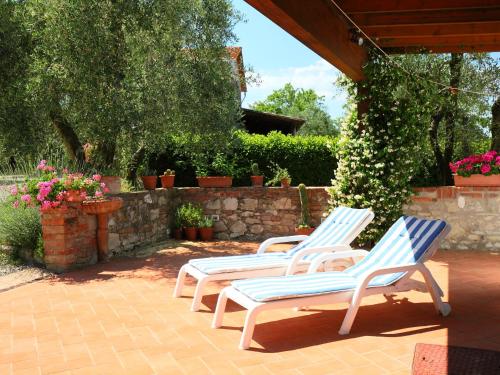 3 chaises longues assises sur une terrasse fleurie dans l'établissement Apartment Cinuzza Grande by Interhome, à Guistrigona