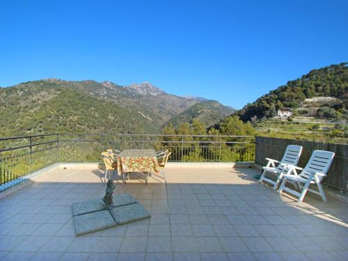 a patio with a table and chairs and mountains at Apartment Taverna Il Cippo by Interhome in Mortola Superiore