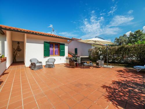 a patio with chairs and an umbrella on a house at Apartment Salita Bellavista by Interhome in Cavo