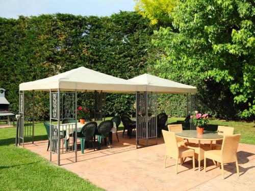 einen Pavillon mit Stühlen und einem Tisch im Garten in der Unterkunft Villa Paolotti by Interhome in Bettona