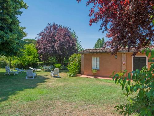 a yard with chairs and a house in the background at Holiday Home Il Fienile del Colle by Interhome in San Gennaro