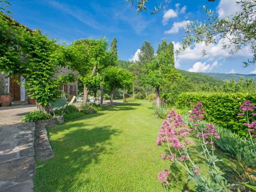 a garden with pink flowers and trees at Apartment I Noccioli by Interhome in Rufina