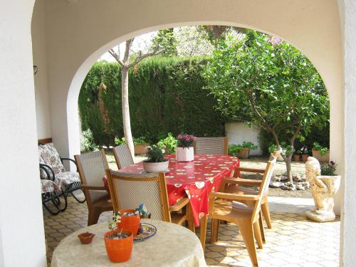 ビラフォルトゥニーにあるHoliday Home Vilafortuny by Interhomeの赤いテーブルクロス付きのテーブルが備わるパティオ