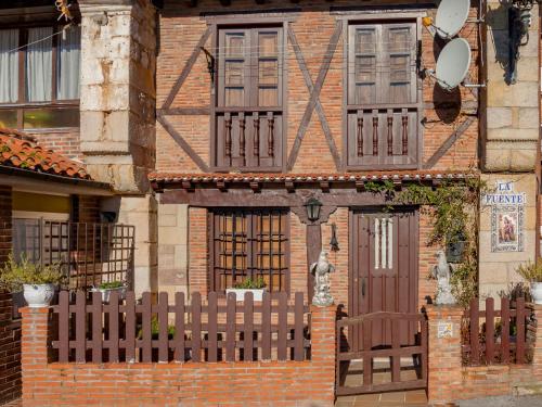 a brick house with a wooden fence in front of it at Holiday Home La Anjana-2 by Interhome in Udias