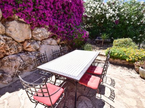 Monte PegoにあるVilla Clementina by Interhomeの花の咲く庭園のテーブルと椅子