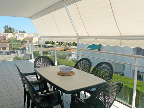 a table and chairs on a balcony with an umbrella at Apartment Turquesa by Interhome in Denia