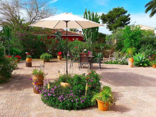 un patio con mesa, sombrilla y flores en Holiday Home B&B by Interhome, en Calpe