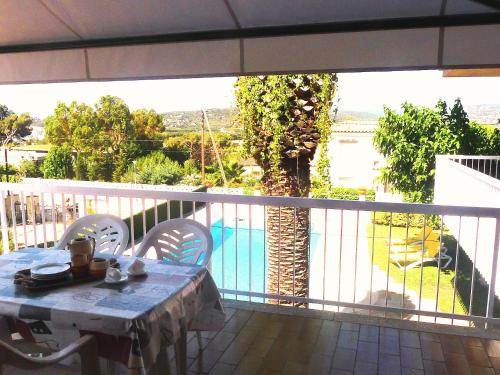 a table on a balcony with a view of a pool at Holiday Home Eva by Interhome in Sant Antoni de Calonge
