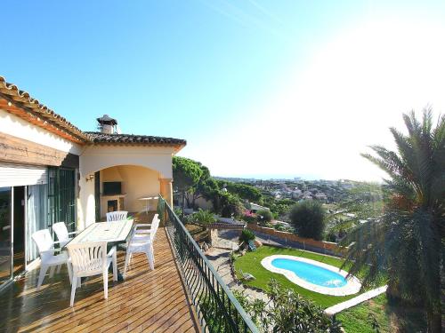 a deck with a table and chairs and a swimming pool at Holiday Home Puig Romani-2 by Interhome in Platja  d'Aro