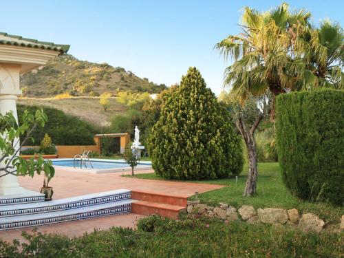カンパニージャスにあるHoliday Home La Poza by Interhomeのヤシの木とスイミングプールのある庭園
