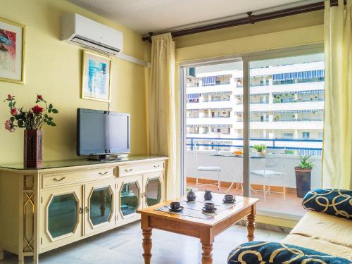 Apartment Las Terrazas by Interhome في مربلة: غرفة معيشة مع تلفزيون وطاولة