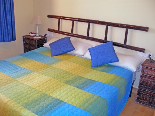 a bedroom with a large bed with blue pillows at Villa Corona by Interhome in Beniarbeig