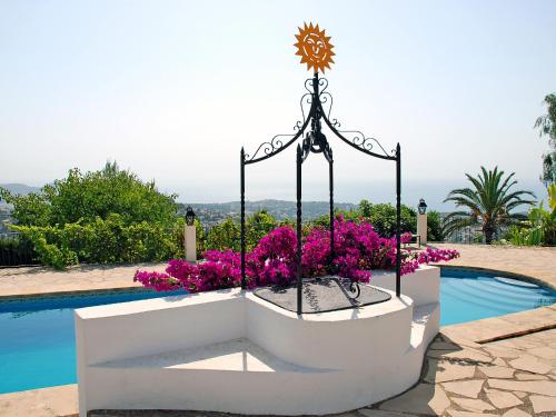 a planter with purple flowers next to a swimming pool at Holiday Home El Baile Del Sol by Interhome in Pedramala