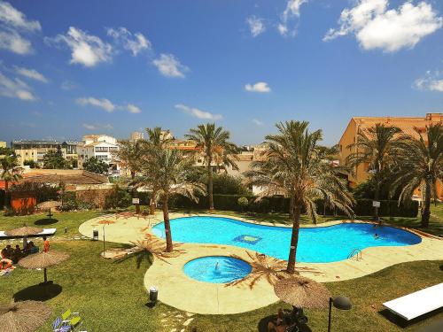 a large swimming pool with palm trees in a resort at Apartment Golden Beach by Interhome in Jávea