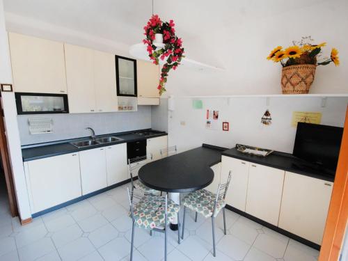 cocina con mesa, sillas y fregadero en Apartment Lecci-2 by Interhome en Eraclea Mare