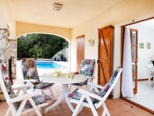 un patio con mesa, sillas y piscina en Holiday Home Cabanyes by Interhome en Calonge