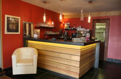 un bar dans un restaurant aux murs rouges dans l'établissement Hotel Corrieu, à La Llagonne