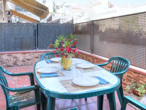a blue table with plates and flowers on a balcony at Apartment Fleming by Interhome in Lloret de Mar