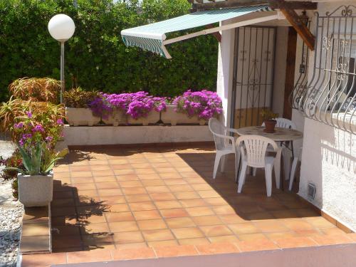 un patio con mesa, sillas y flores en Holiday Home Mimosa-3 by Interhome, en Denia