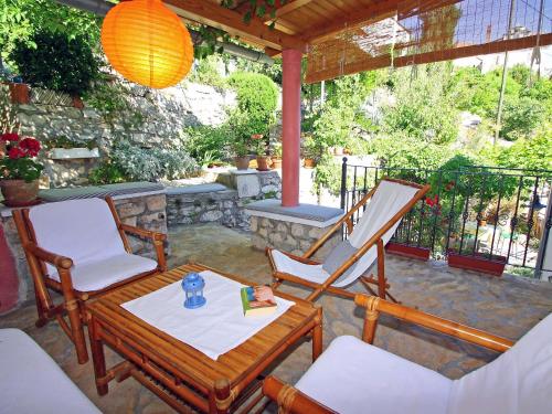 a patio with two chairs and a table and a hammock at Holiday Home Mirna by Interhome in Ložišće