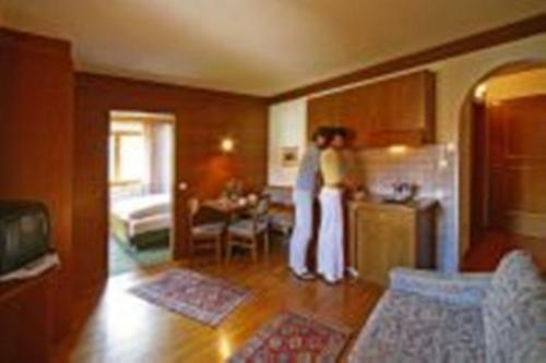 zwei Frauen stehen in einer Küche mit Kühlschrank in der Unterkunft Hotel Garní Sunnleit´n in Welsberg-Taisten