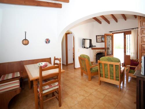 a living room with a table and chairs and a fireplace at Holiday Home Heidi by Interhome in Empedrola