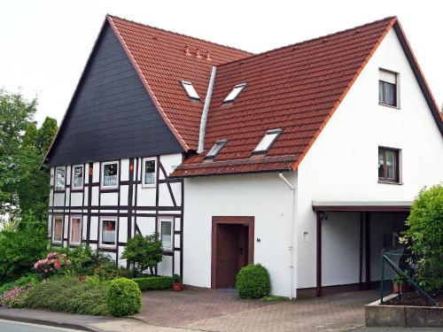 a white and black house with a red roof at Apartment Kopei by Interhome in Eschenbruch