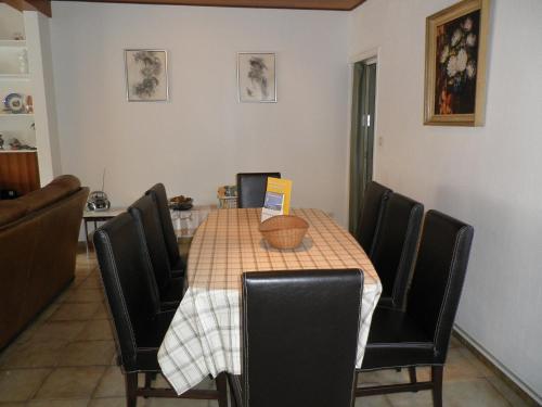a dining room table with black chairs and a table with a laptop at Apartment Poperinge by Interhome in Poperinge