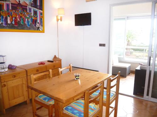 uma sala de jantar com uma mesa de madeira e cadeiras em Apartment La Plage Dorée by Interhome em Bandol