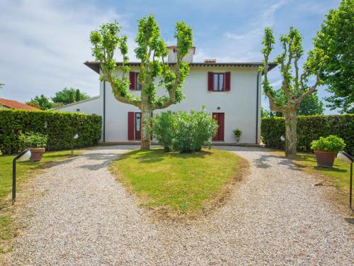 a white house with red doors and trees at Villa Villa Ponticelli by Interhome in Lavaiano
